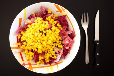 Siyah masada mısırlı salata, üst manzara. Gıda arkaplanı