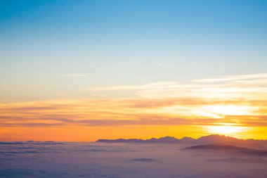 İtalyan Alpleri 'nden gün batımında dağ silueti. Bulutlar arka plan
