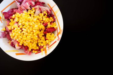 Siyah masada mısırlı salata, üst manzara. Gıda arkaplanı