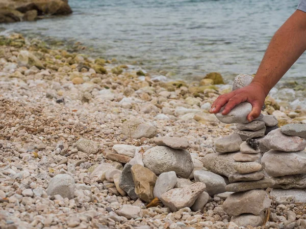 Mão Homem Segurando Pedra Branca Construindo Pedras Zen Praia — Fotografia de Stock