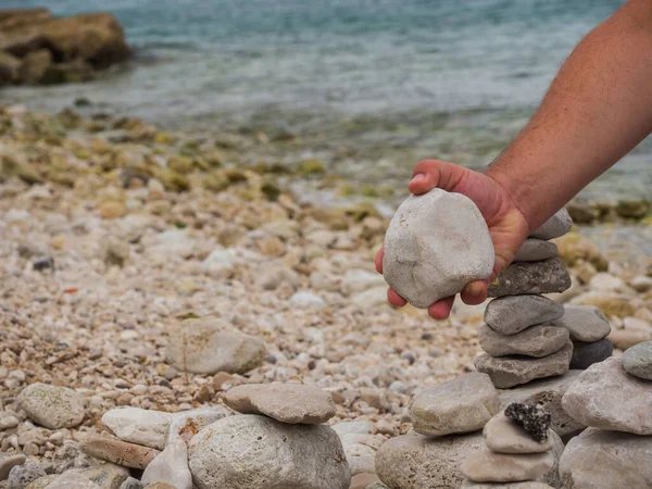 Mão Homem Segurando Pedra Branca Construindo Pedras Zen Praia — Fotografia de Stock