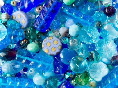 Detaylı arkaplanda çeşitli mavi renklerde parlak boncuklar.