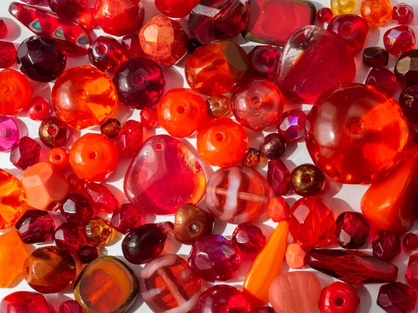 Sparkling colorful beads in various red colors in detail background