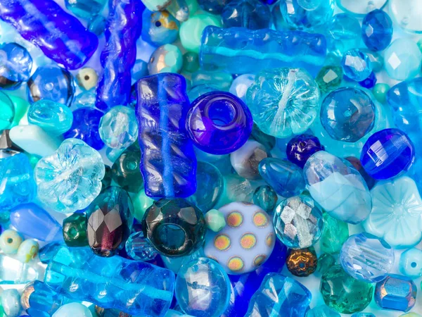 Detaylı arkaplanda çeşitli mavi renklerde parlak boncuklar.