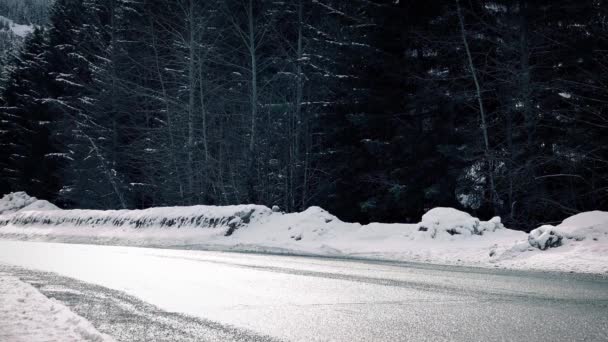 Auto passiert winterliche Autobahn in der Sonne — Stockvideo