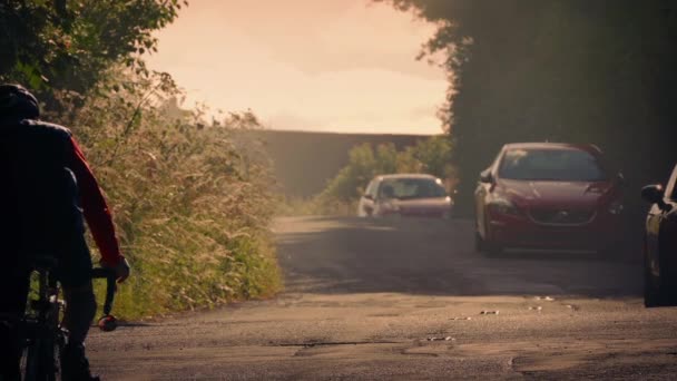 Ciclista na estrada do país ao pôr do sol — Vídeo de Stock