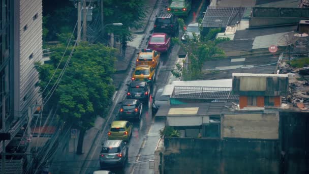 Autos fahren an Regentagen an Slums vorbei — Stockvideo
