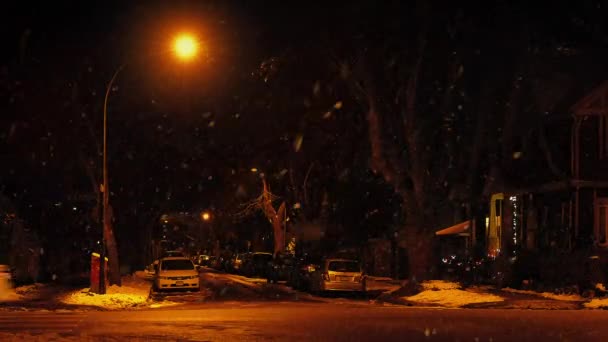 Voitures conduisent la route passée de ville avec la neige tombant — Video