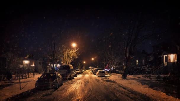 Жилой район под сильным снегопадом ночью — стоковое видео