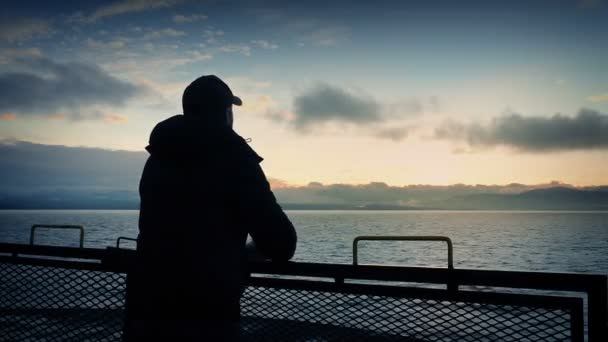 Mann blickt bei Sonnenuntergang von der Rückseite des Schiffes — Stockvideo