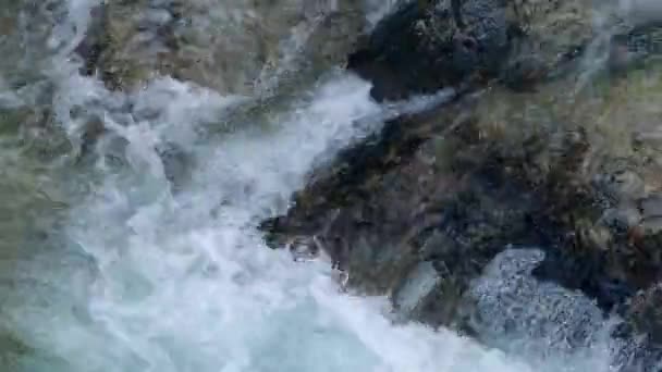 Fluss rauscht über bunte Felsen — Stockvideo