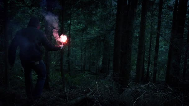Mannen med Flare stiger ned skogen sluttningen — Stockvideo