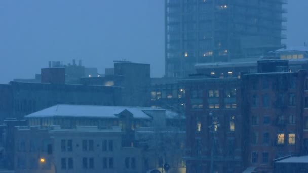 Edificios de la ciudad en nevadas en la noche — Vídeos de Stock