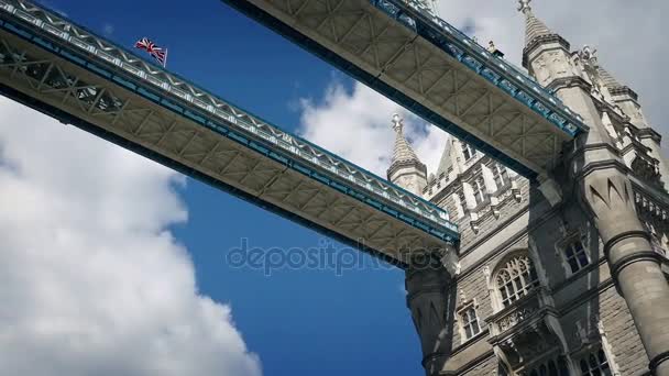 Przemieszczających się w ramach Tower Bridge z flaga dmuchanie — Wideo stockowe