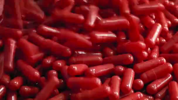 Cápsulas rojas de la salud vertidas en la pila — Vídeos de Stock