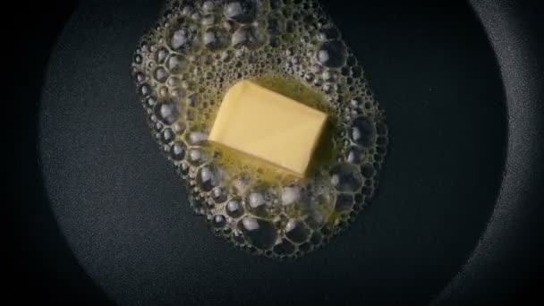Растапливание масла в сковородке — стоковое видео