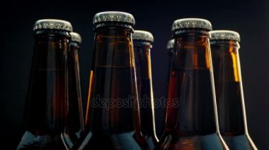 Siyah arka plan üzerine dönen bira şişeleri