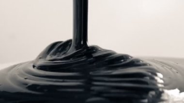 Kalın siyah boya beyaz yüzey üzerinde dökülen