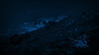 Gece denizde tarafından rüzgârlı çimenli kayalıklarla