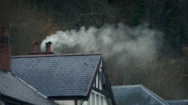 Kasaba 'da baca sigara içiyor.