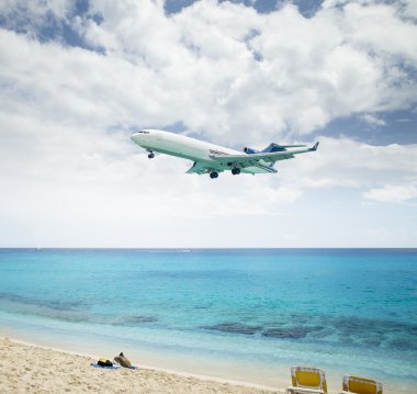 Plane landing over Maho Beach in Saint Martin island clipart