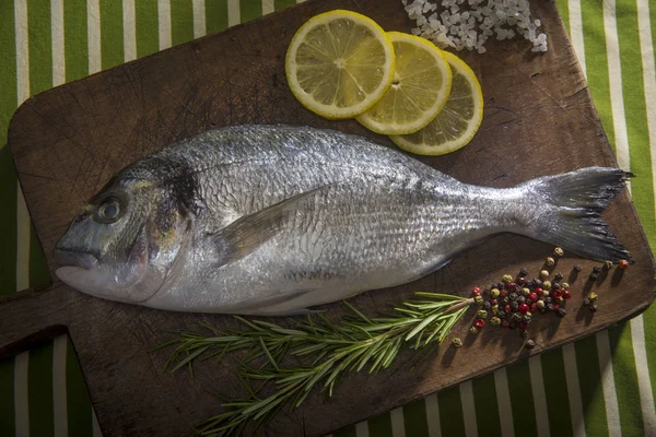 Peixes de sargo marinhos frescos numa tábua de corte de madeira — Fotografia de Stock