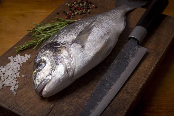 Delicious fresh sea bream fish on a wooden cutting board — Stock Photo, Image