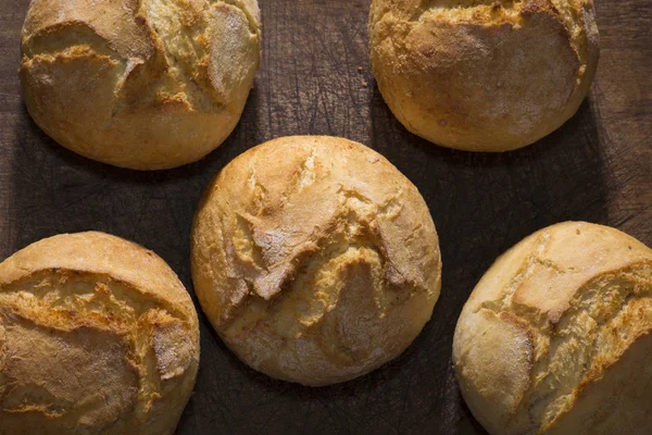 Petits pains rustiques traditionnels sur une planche à découper vintage — Photo