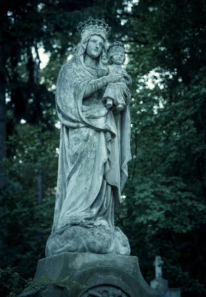 Stará kamenná socha sv. Marie s Ježíšovým dítětem na hřbitově — Stock fotografie