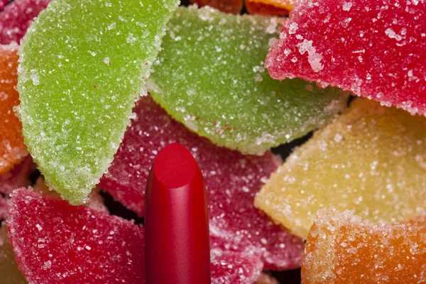 Rött läppstift på en bakgrund av sötsaker — Stockfoto