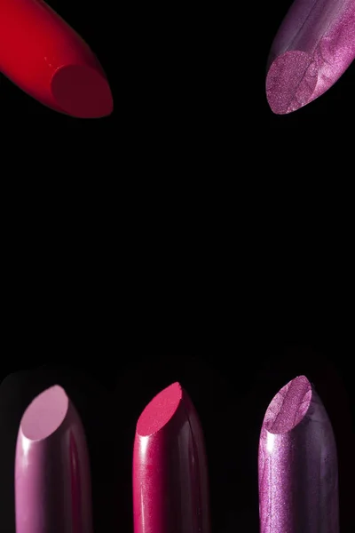 Drei schöne Lippenstifte auf schwarzem Hintergrund — Stockfoto