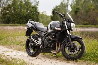 Elektrik santralinin yanında siyah spor motosikleti..