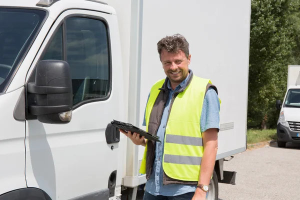 Mannelijke werknemer vooraan truck gebruik mobiele telefoon — Stockfoto