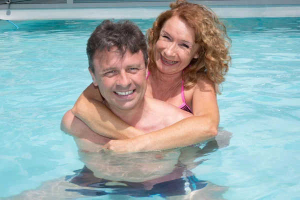 L'uomo in piscina restituisce un porcellino a una donna — Foto Stock