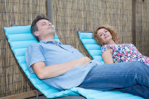 Пара розслабляється на шезлонгу біля басейну — стокове фото
