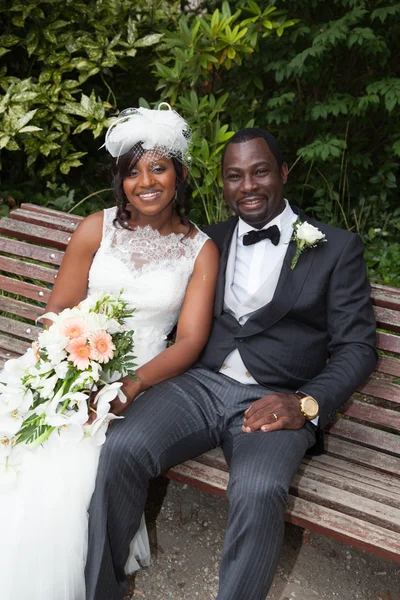 Jovem casal afro-americano recém-casado em um banco — Fotografia de Stock
