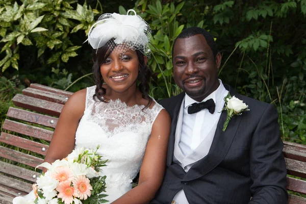 Feliz casal afro-americano recém-casado em um banco — Fotografia de Stock