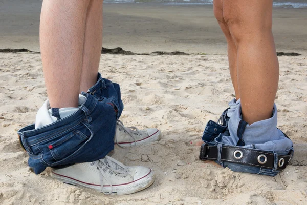 Paar man en vrouw voeten in liefde romantische buiten. Benen in jeans en sneakers. — Stockfoto