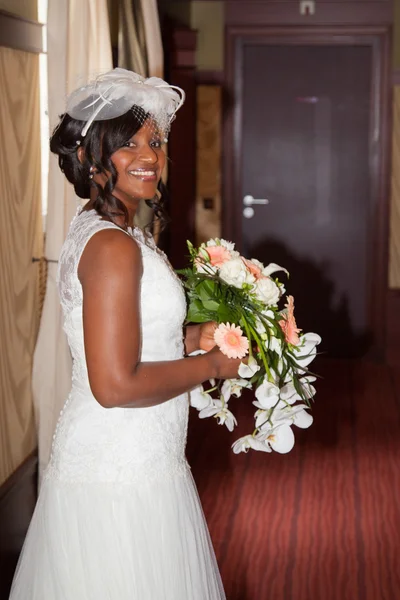 Vista lateral de uma noiva americana africana bonita segurando flores — Fotografia de Stock