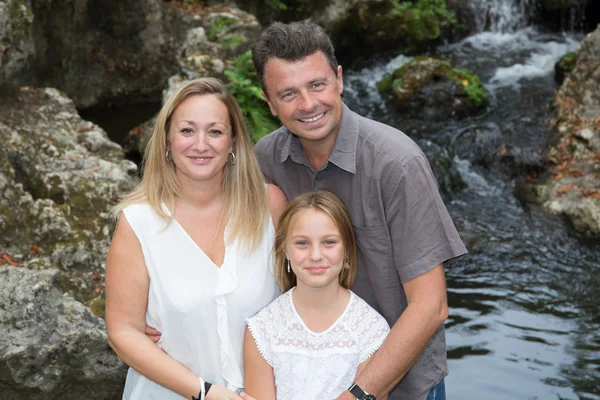 Famille heureuse de trois personnes s'amusant ensemble en plein air . — Photo