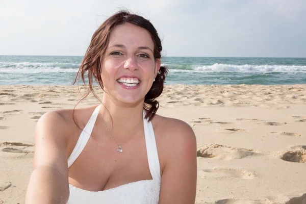 Bella sposa sorridente alla fotocamera in spiaggia estate — Foto Stock