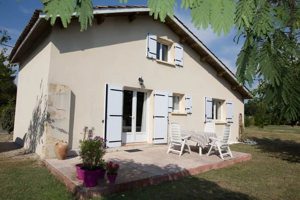 Schönes Haus außen mit blauen Fenstern und Garten — Stockfoto