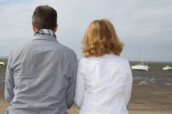 Vista posteriore di una coppia romantica seduta su un molo . — Foto Stock