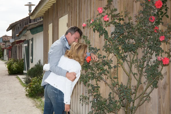 Et par turister på ferie som lukter blomster. – stockfoto