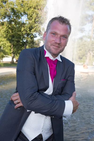 Homem com smoking e gravata rosa, braços cruzados — Fotografia de Stock