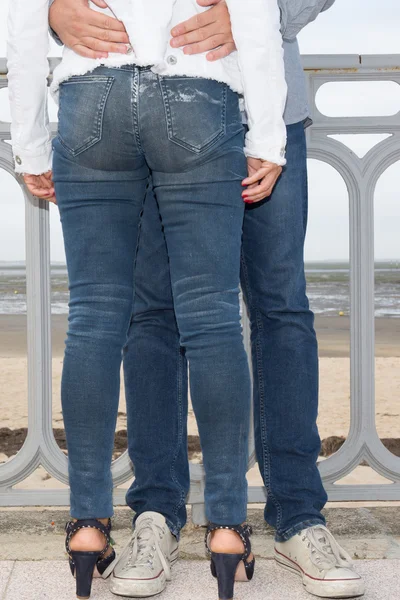 Joli couple en jeans flirtant sur la plage — Photo