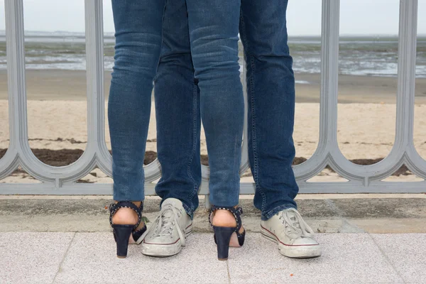 Mooie paar dragen van jeans flirten op het strand — Stockfoto