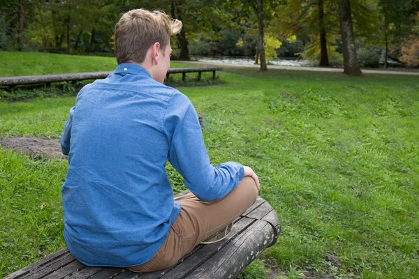 Man doet yoga pose lotus. Jonge man het beoefenen van yoga fitness oefening outdoo — Stockfoto