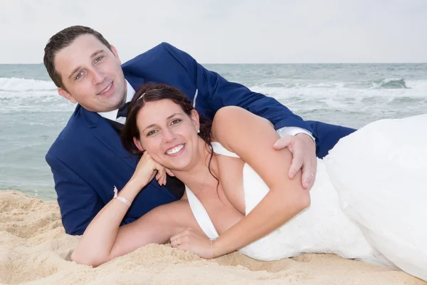 Braut und Bräutigam verliebt im Sand — Stockfoto