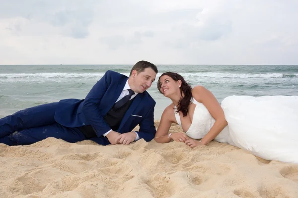 Braut und Bräutigam verliebt im Sand — Stockfoto